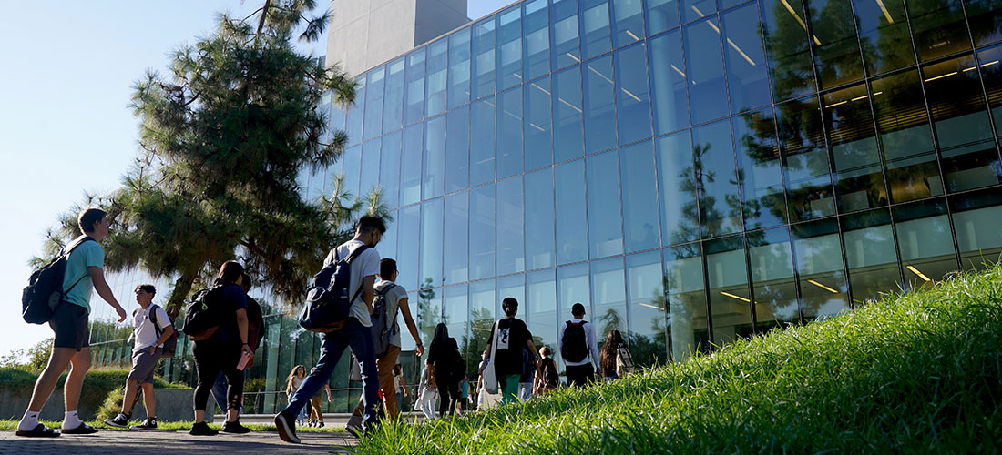 Student walking in front of library